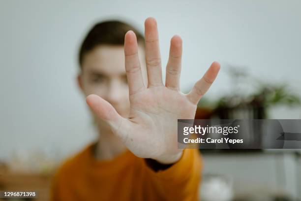 teenager boy open palm.stop gesture - verteidigen stock-fotos und bilder