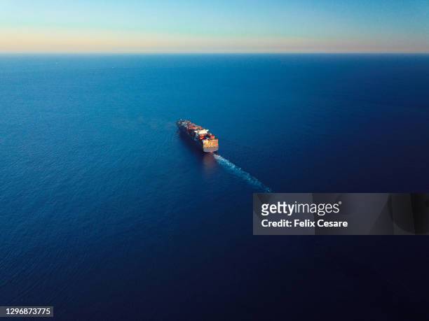 aerial view of a cargo ship on the move in the middle of the sea. - cargo ships stockfoto's en -beelden