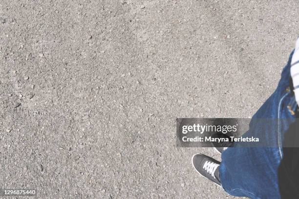 legs in sneakers on the asphalt with a shadow. - street above stock pictures, royalty-free photos & images