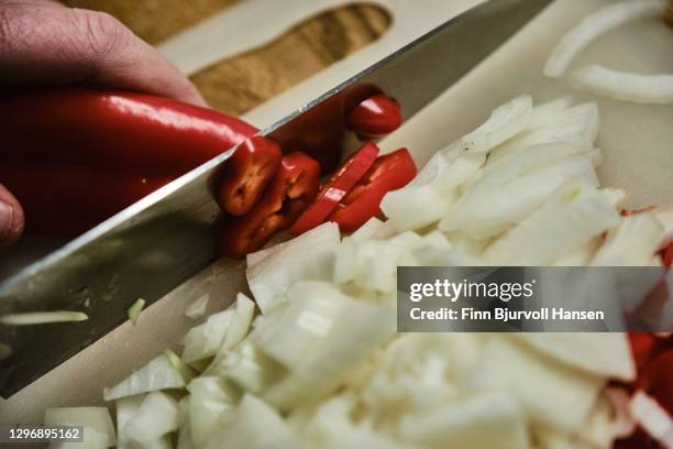 hand cutting onions and red peppar with a knife - peppar 個照片及圖片檔