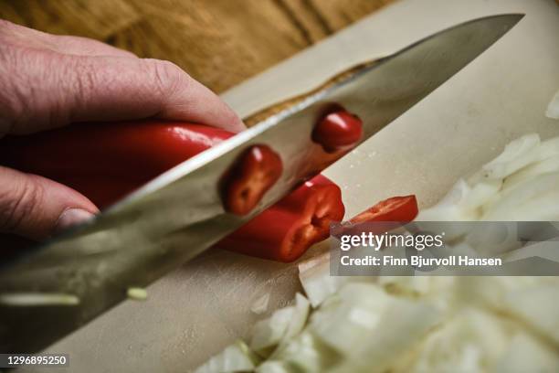 hand cutting onions and red peppar with a knife - peppar 個照片及圖片檔