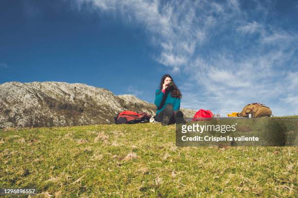 mujer bebiendo agua y descansando durante una ruta de montaña - descansando stock-fotos und bilder