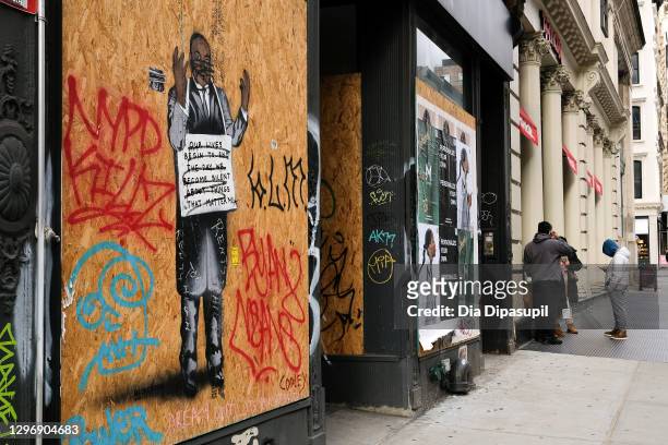 View of vandalized street art of Dr. Martin Luther King, Jr. On a boarded-up storefront in the SoHo neighborhood of Manhattan on January 17, 2021 in...