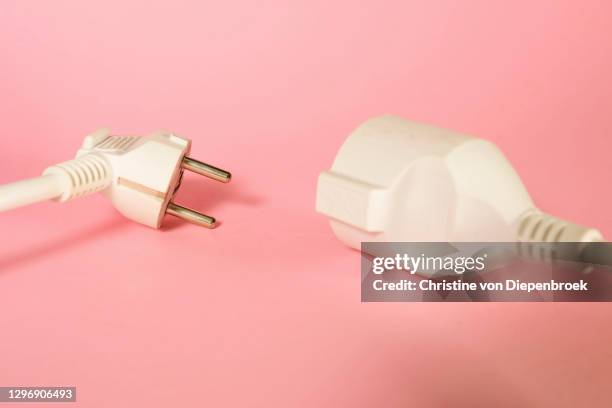 white extension cord on plain background - plug in stock-fotos und bilder