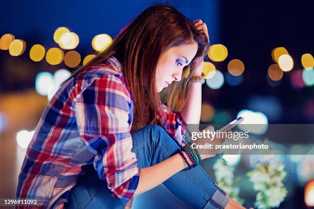 depressed, young girl is texting on the bridge - abuse stock pictures, royalty-free photos & images