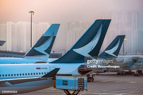 cathay tails with high rise in hazy background - cathay pacific stock pictures, royalty-free photos & images