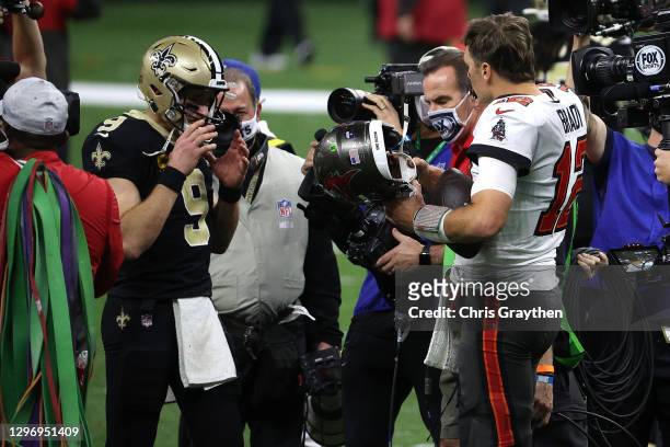 Drew Brees of the New Orleans Saints talks with Tom Brady of the Tampa Bay Buccaneers after their NFC Divisional Playoff game at Mercedes Benz...