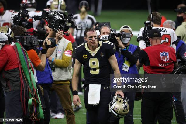 Drew Brees of the New Orleans Saints walks off the field after being defeated by the Tampa Bay Buccaneers in the NFC Divisional Playoff game at...