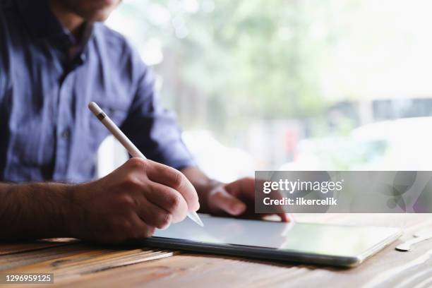 man writing or signing on digital tablet using stylus - signing tablet stock pictures, royalty-free photos & images