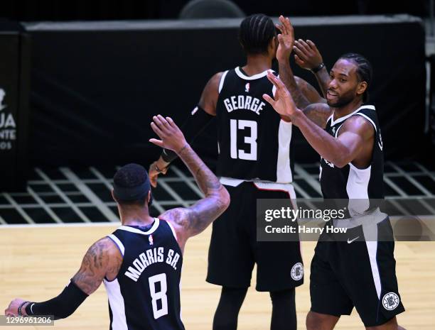 Kawhi Leonard of the LA Clippers celebrates is basket off of a Clipper free throw, with Paul George and Marcus Morris Sr. #8, to end the third...