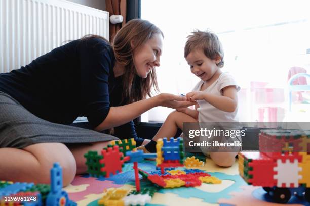 la mère heureuse et le fils d’enfant en bas âge jouent ensemble à la maison avec des jouets - parent denfant adulte photos et images de collection