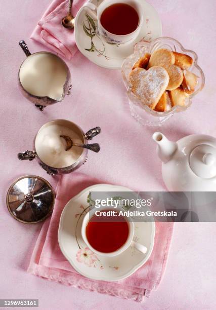two cups of tea and cookies on table - アフタヌーンティー ストックフォトと画像