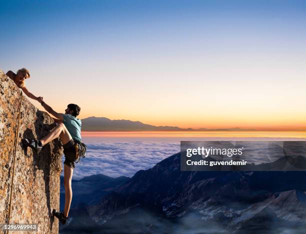 wandelaars helpen - team climbing up to mountain top stockfoto's en -beelden