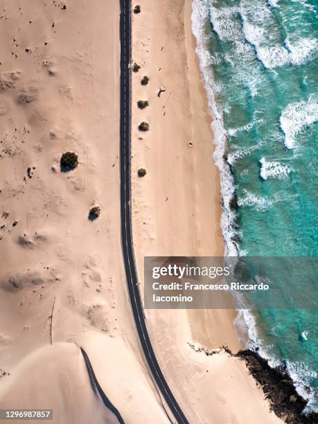 aerial view of road near ocean and corralejo desert dunes, fuerteventura - francesco riccardo iacomino spain stock pictures, royalty-free photos & images