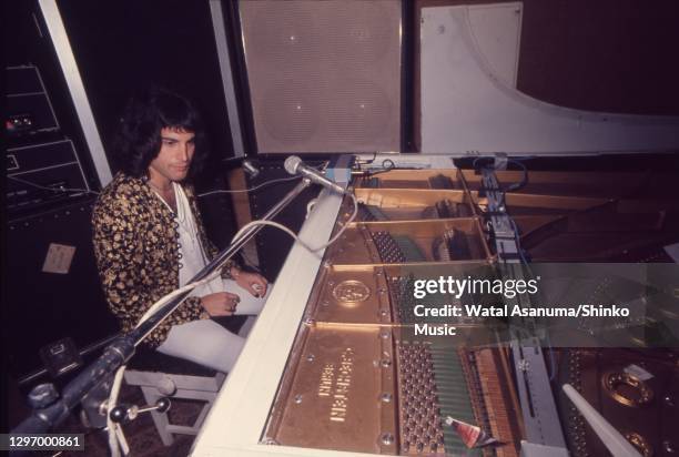 Freddie Mercury of Queen at a white Bechstein grand piano during rehearsing and recording of 'A Night At The Opera' album at Ridge Farm Studios, West...