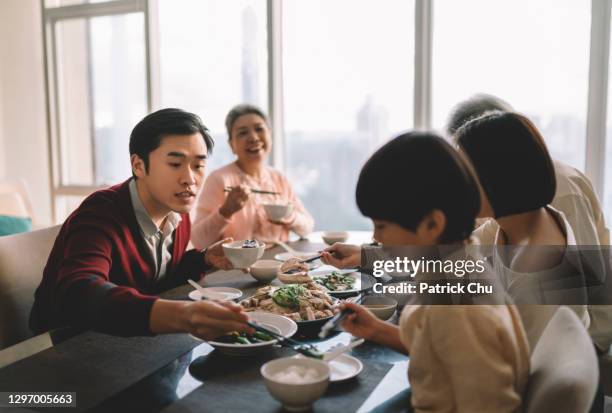 aziatische chinese familie die reüniediner tijdens chinees nieuwjaar thuis heeft - 65 year old asian women stockfoto's en -beelden