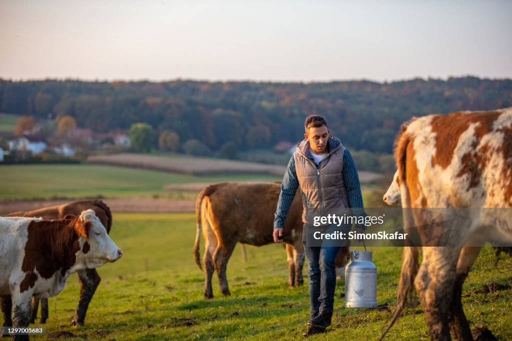 Young man walking with milk canister in his hand