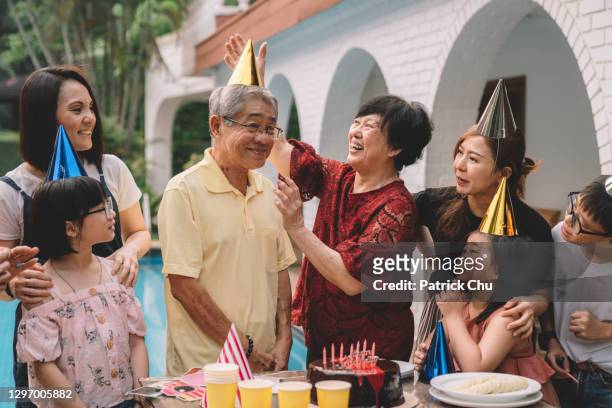 asiatische chinesische mehrgenerationenfamilie feiert opa geburtstag - chinese birthday stock-fotos und bilder