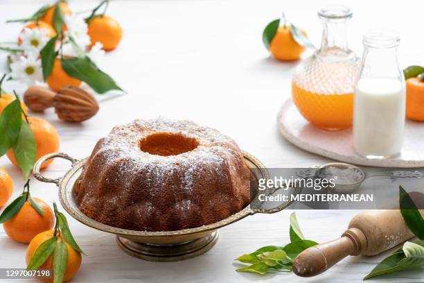 torta bundt a base di clementine di mandarino cotte in casa con ingredienti su bianco - torta foto e immagini stock