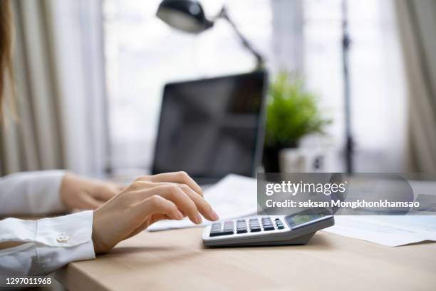 close up grandmother hand press on calculator for counting about monthly expense or planning money management after retired concept - wages stockfoto's en -beelden