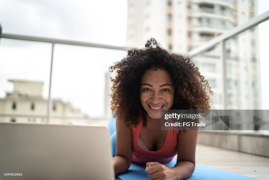 Portrait of a woman using laptop for home workout