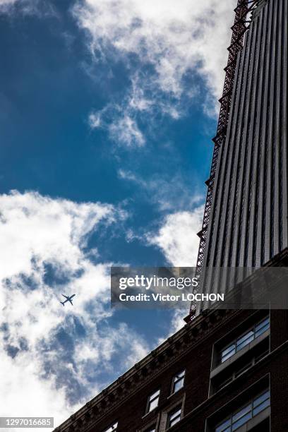 Avion de ligne dans le ciel et building, 6 mai 2019, New York, Etats-Unis.