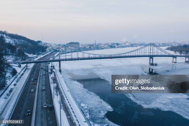 scenic aerial view of bridge above frozen river in kyiv - dnieper river stock pictures, royalty-free photos & images