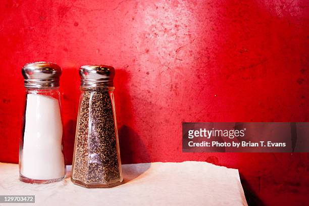 salt and pepper shakers against  red wall - service à condiments photos et images de collection