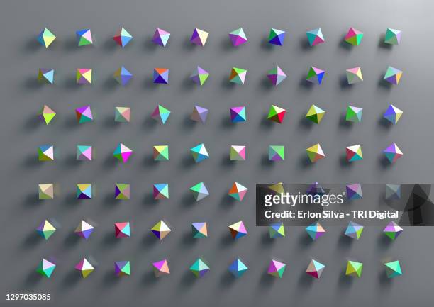 graphic design of multicolored polygonal geometric shapes on gray background - three dimensional pyramid stock pictures, royalty-free photos & images