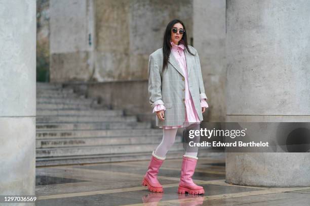 Gabriella Berdugo wears sunglasses, a pink ruffle dress with collar from Avavav, a beige vintage oversized blazer jacket with checked print, white...