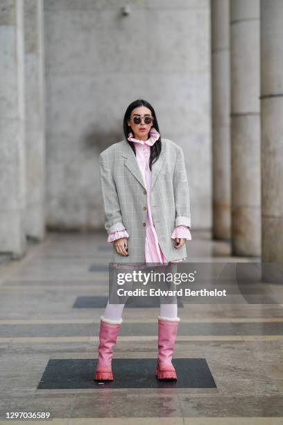 Gabriella Berdugo wears sunglasses, a pink ruffle dress with collar from Avavav, a beige vintage oversized blazer jacket with checked print, white...