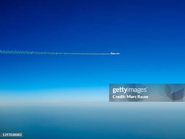 a lonely boeing 777 aircraft with contrail in a deep blue sky - clear sky plane stock pictures, royalty-free photos & images