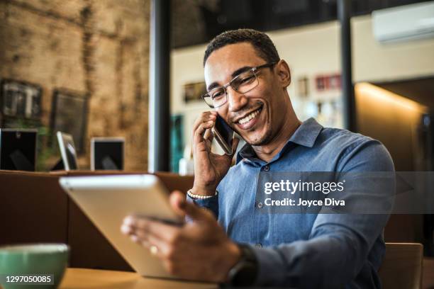 jonge zakenman die een digitale tablet in een modern bureau gebruikt - young businessman digital tablet stockfoto's en -beelden