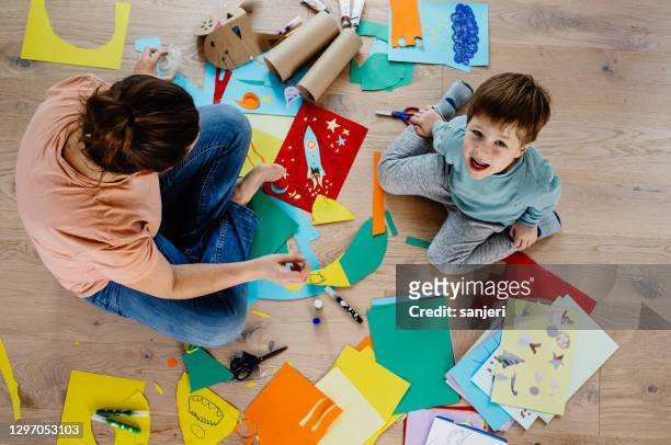 madre e hijo cortando papel y haciendo collages - fotografía producto de arte y artesanía fotografías e imágenes de stock
