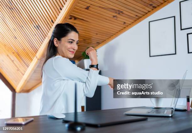 glückliche junge geschäftsfrau macht dehnübungen und übt büroyoga im home office. - ergonomie stock-fotos und bilder