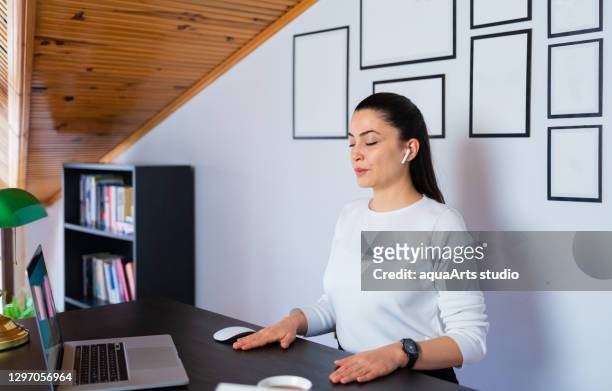 entspannte ruhige geschäftsfrau nehmen tiefen atem der frischen luft ruhen mit augengeschlossenen bei der arbeit im home office. büro-yoga und meditieren mit geschlossenen augen. - mindfulness stock-fotos und bilder