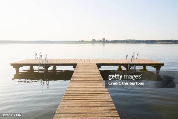 jetty at an idyllic lake with smooth water, tranquil scene - ponton photos et images de collection