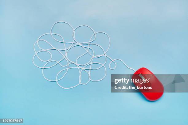 still life of an abstract cloud from wool thread and red computer mouse on blue background - www stock-fotos und bilder