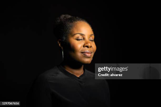 afrikaanse vrouw met haar gesloten ogen - casual woman pensive side view stockfoto's en -beelden