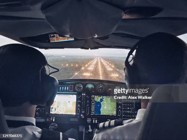 pilot in cockpit of small private aircraft landing at night. - co pilot stock pictures, royalty-free photos & images