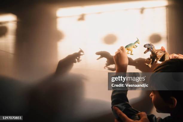 menino brincando com sombras - dinosaur toy i - fotografias e filmes do acervo