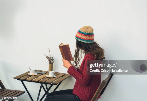 young woman reading a book in a cafeteria terrace - city book stock pictures, royalty-free photos & images