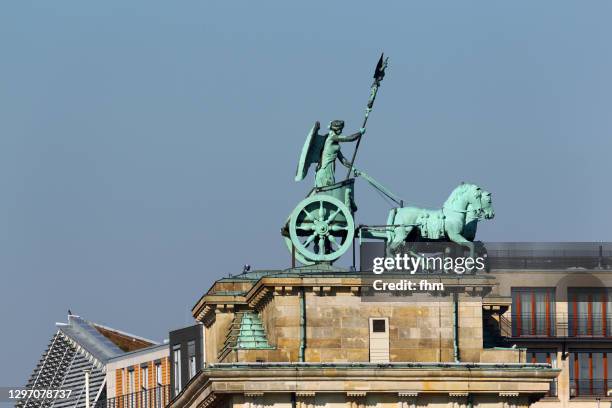 quadriga statue on the brandenburg gate in berlin (germany) - quadriga statue brandenburg gate stock-fotos und bilder