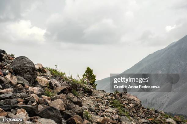 crossing mountains is like a mail envelope. trail in the mountains. a sign of where to go in the mountains is a cairn. - steep stock pictures, royalty-free photos & images