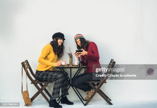 mother and adult daughter having coffee - té terraza fotografías e imágenes de stock