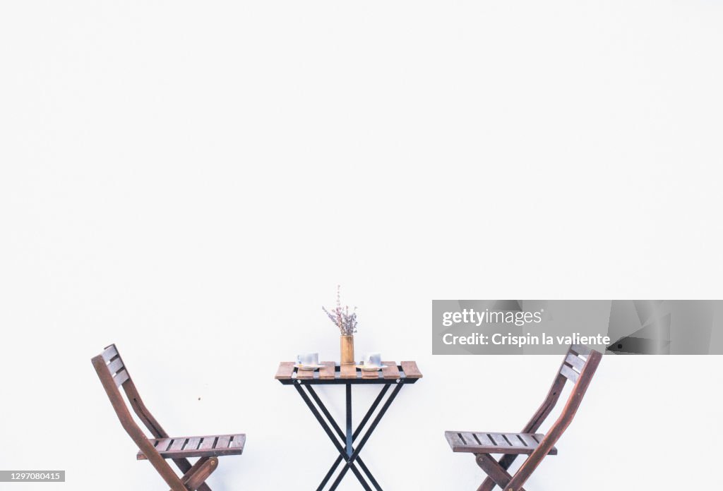 Wooden table of a terrace and chairs of a bar with white background