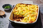 Vegan shepherd's pie with lentils and mashed potatoes in black backing dish. Vegan healthy food concept.