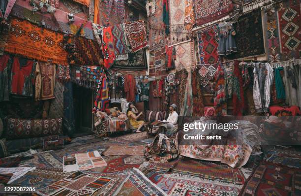 young tourists enjoying at traditional carpet shop in cappadocia, turkey - bazaar stock pictures, royalty-free photos & images