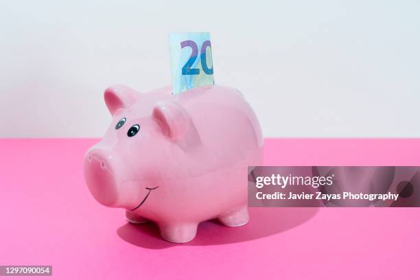 piggy bank and a twenty euro note on pink background - twenty euro note stock-fotos und bilder