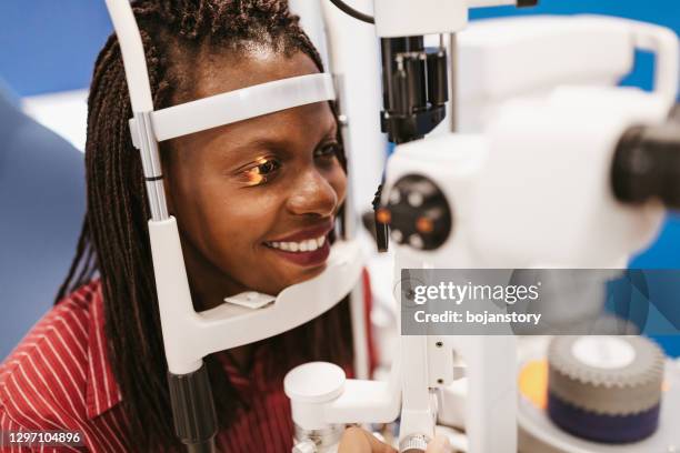 young woman during an eyesight exam - eye test equipment stock pictures, royalty-free photos & images